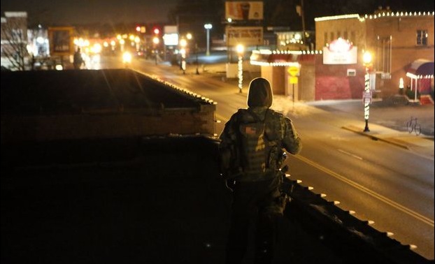 A member of the Oath Keepers (who did not want to be identified) watch the area north of the police station from the rooftop of buildings along South Forissant Road in the early hours of Friday, Nov. 28, 2014, in Ferguson. Photo by Huy Mach - hmach@post-dispatch.com