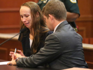 Heather Hironimus, sitting with her attorney Thomas Hunker, breaks down as she signs consent for her 4-year-old son to be circumcised, during a hearing, Friday, May 22, 2015, in Delray Beach, Fla. Hironimus' yearslong battle against her child's father over the boy's circumcision ended Friday, with her agreeing to the procedure in exchange for her release from jail. (Amy Beth Bennett/South Florida Sun-Sentinel via AP)  MAGS OUT, NO SALES