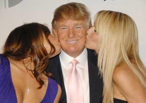 Real estate tycoon Donald Trump, center, gets kisses from his wife Melania, left, and model Heidi Klum at a party to introduce The Trump International Hotel & Tower Dubai, hosted by the real estate development company Nakheel, on Monday, June 23, 2008, in New York. (AP Photo/Evan Agostini)